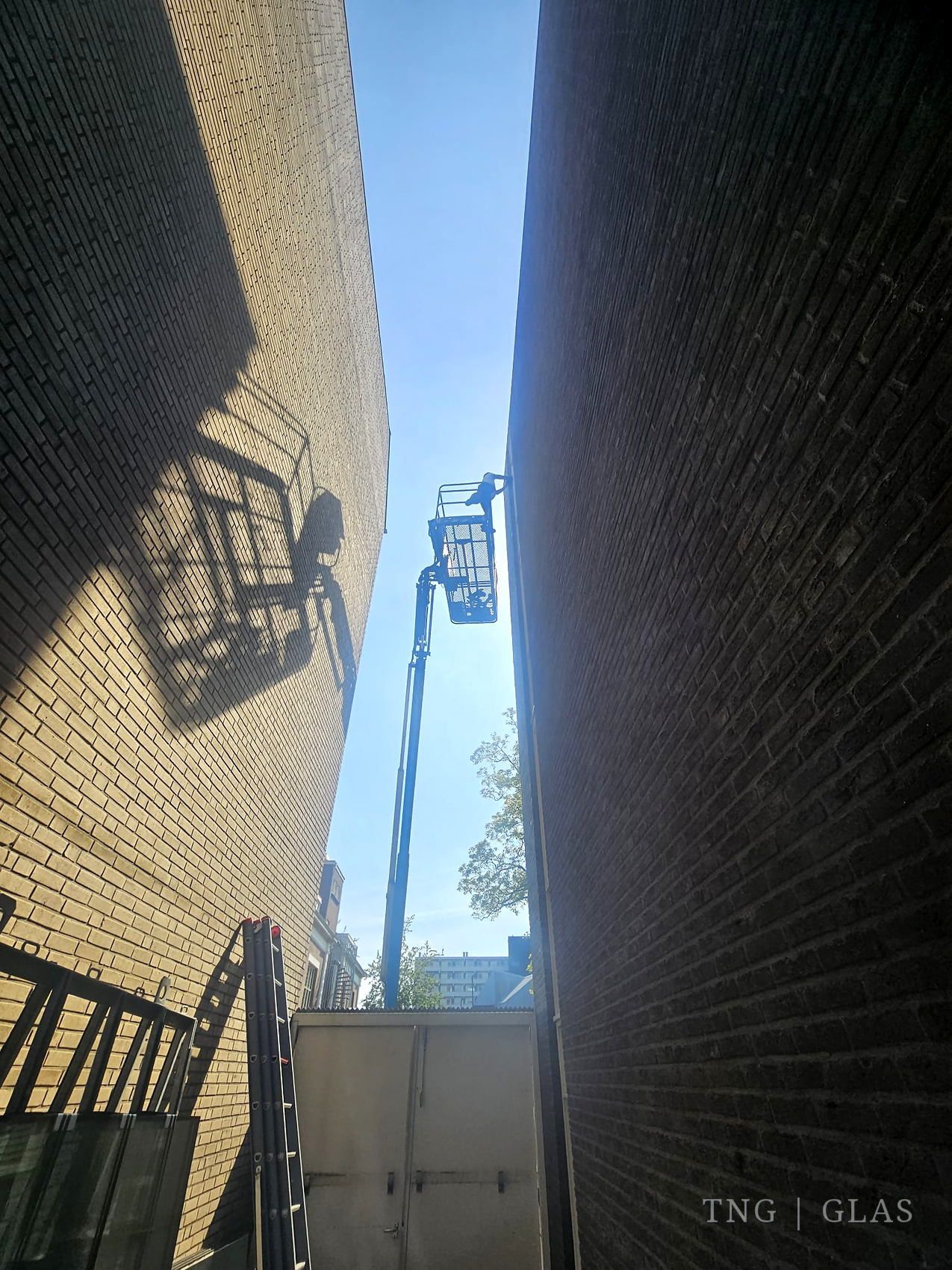 Hoogwerker in gebruik bij de glasvervanging van het appartementencomplex in Veenendaal
